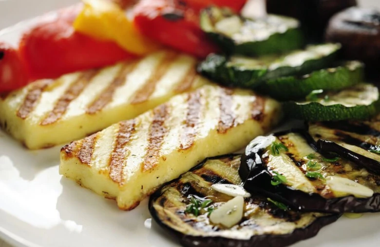 Grilovaný sýr Halloumi se zeleninou na bílém talíři