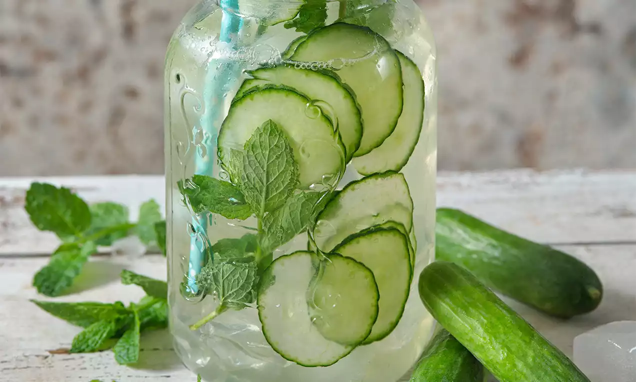 Sklenice s okurkovou limonádou, mátou a kousky okurek.