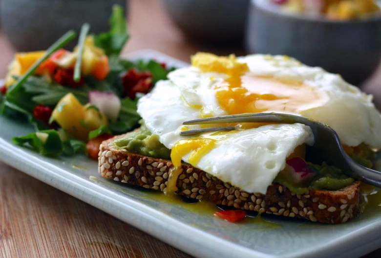 Zdravá snídaně: toasts s avokádem, vejcem a salát.