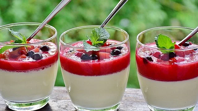 Tři skleničky s panna cottou ovocnou vrstvou a mátou.