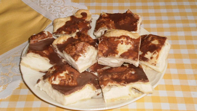 Kusy čokoládového koláče Mrak na talíři s žlutou ubrouskem.