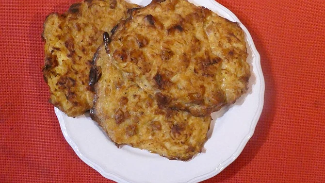 Zlatohnědé pečené zelné placky na bílém talíři.