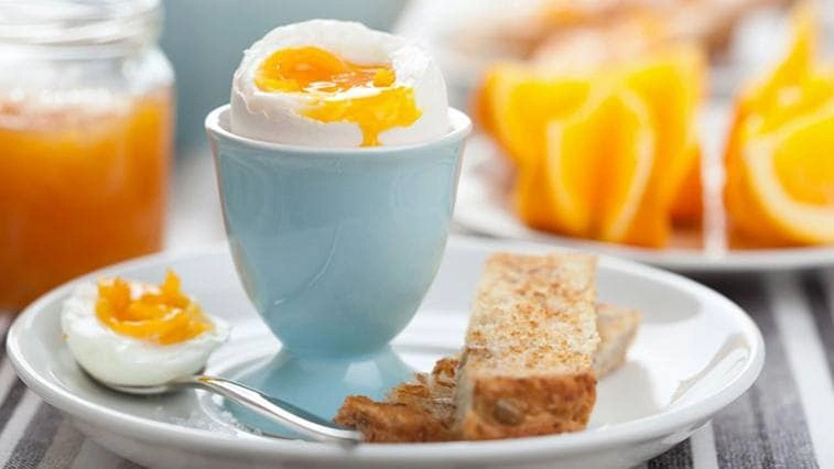 Soft-boiled egg with toast and orange juice