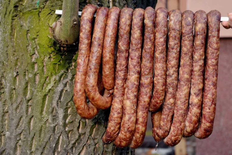 Domácí klobásy visící na stromě po usušení.
