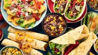 Různá mexická jídla jako taquitos, nachos a tacos s čerstvou zeleninou.