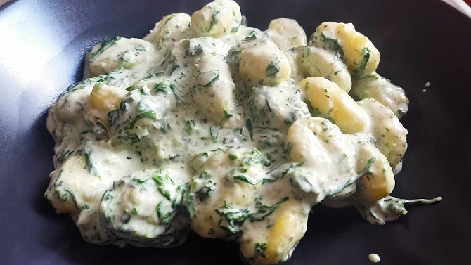 Spinach gnocchi with cheese sauce