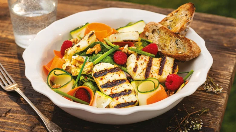Grilovaný sýr halloumi v salátu se zeleninou a chlebem.