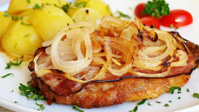 Přepážka s vepřovým řízkem naruby se žloutkem a cibulí