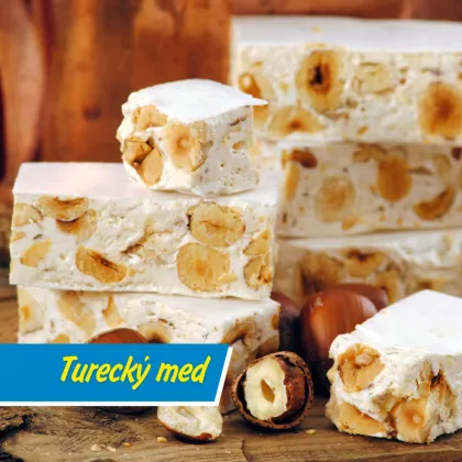 Kusky turecký med s ořechy na dřevěném povrchu.