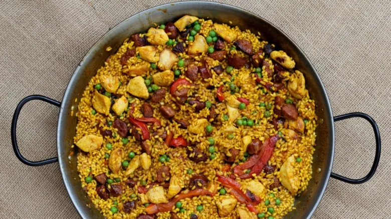 Paella s kuřecím masem a rýží v hrnci