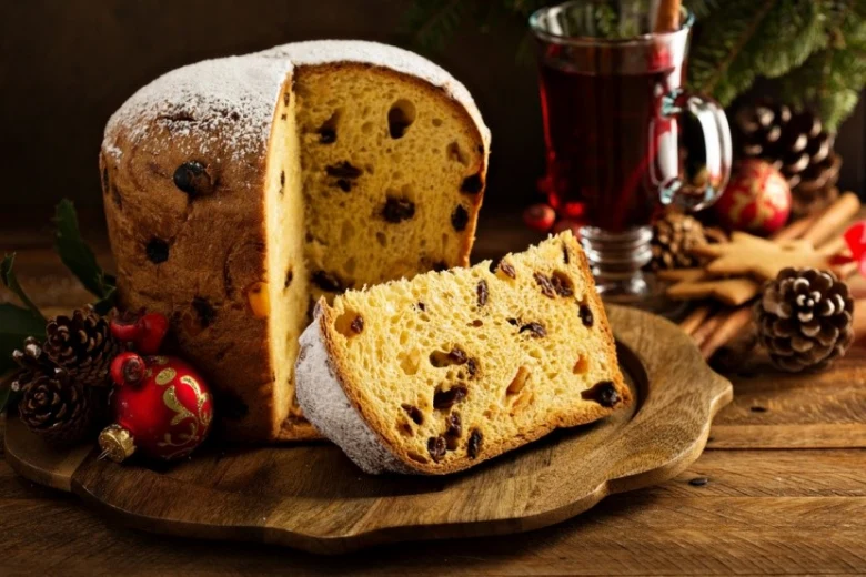 Tradiční italské panettone s kouskem na dřevěném talíři.