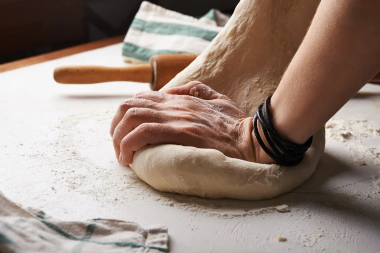 Ruční kynutí těsta na pizzu s moukou.