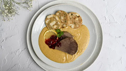Připravená svíčková s omáčkou a knedlíky na talíři.