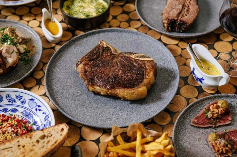 Připravený hovězí steak na pánvi s přílohami.