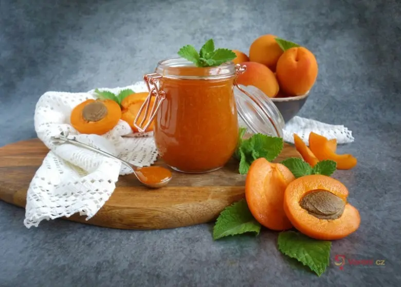Sklenice domácí meruňkové marmelády s čerstvými meruňkami.