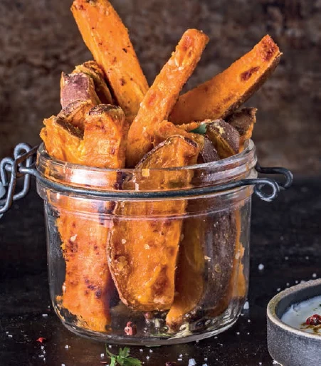 Sklenice plná pečených batátů připravených v horkovzdušné fritéze.