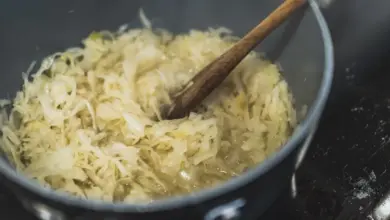 Kysané zelí se vaří v hrnci s dřevěnou lžící.