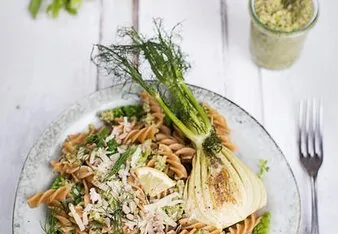 Veganský salát s těstovinami a cibulkou na talíři.
