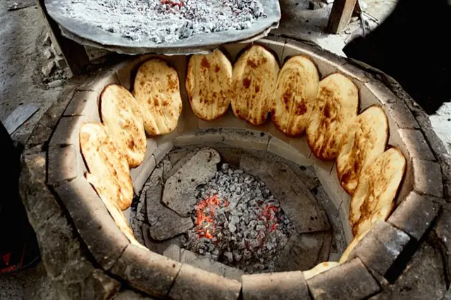 Tradiční chléb lavash pečený v hlíněné peci s uhlími.