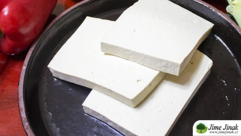 Tři kusy bílého tofu na tmavém talíři připravené k vaření.