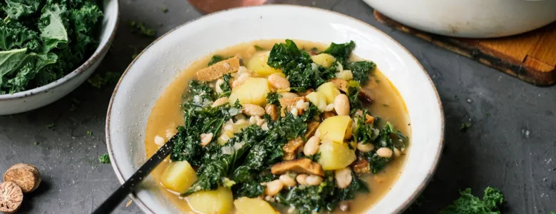 Mísa s veganskou polévkou ze špenátu, brambor a fazolí.