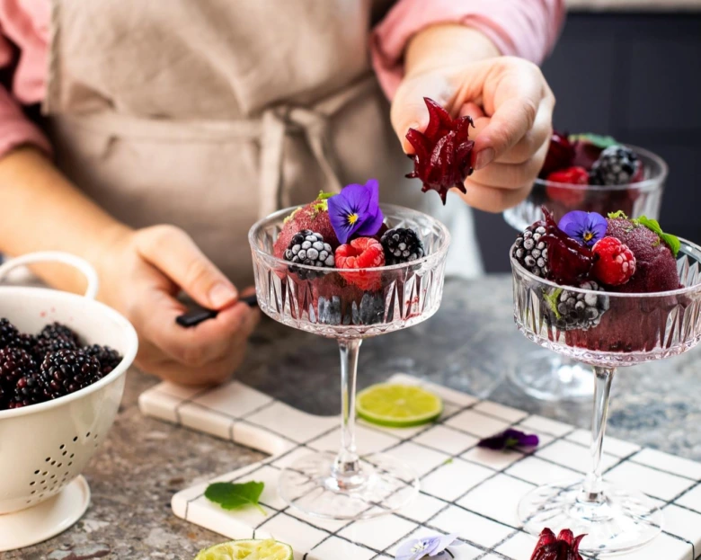 Domácí ovocný sorbet z borůvek s čerstvým ovocem a květinami