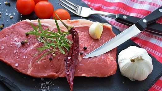 Surové hovězí svíčková s bylinkami, česnekem a kořením na kameni.