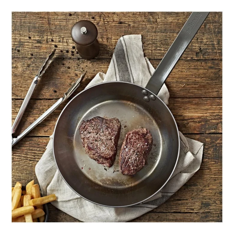 Dva sezónované steak na pánvi se hranou křupavých brambor.