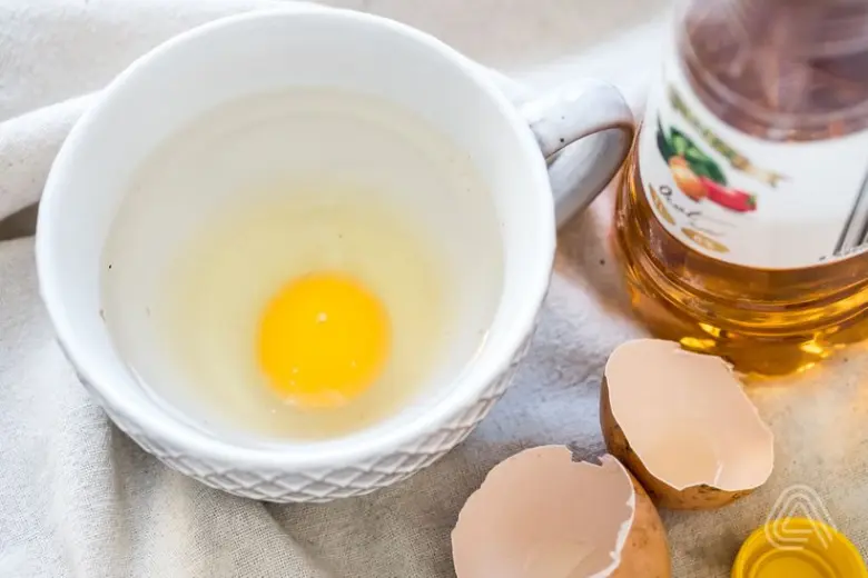 Surové vejce v šálku s olejem pro recept na zastřené vejce