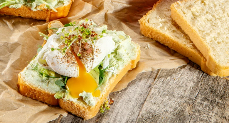 Připravený toast s avokádem a vařeným vejcem na chlebu.