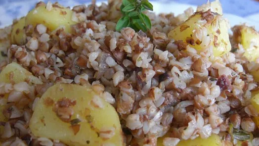 Pohanka vařená s bramborami a bylinkami na talíři.