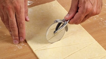 Rezač na pizzu řeže listové těsto na proužky.