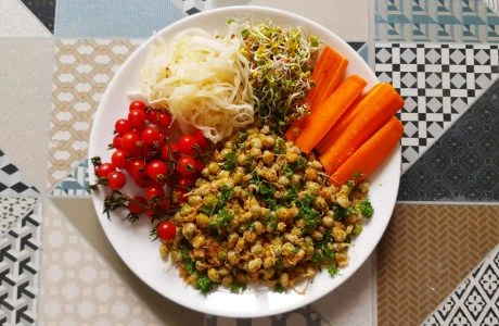 Připravená veganská jídla s čočkou a zeleninou na talíři.