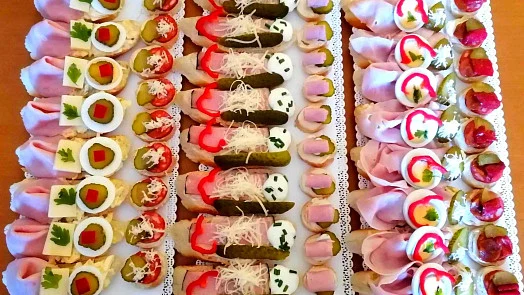 Různé druhy slané party kanapé na bílých talířích.