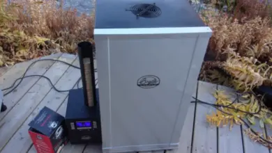 Elektrický kuřák s teploměrem pro sledování vnitřní teploty masa.
