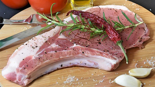 Syrové opečené vepřové kotlety s bylinkami, kořením a česnekem.