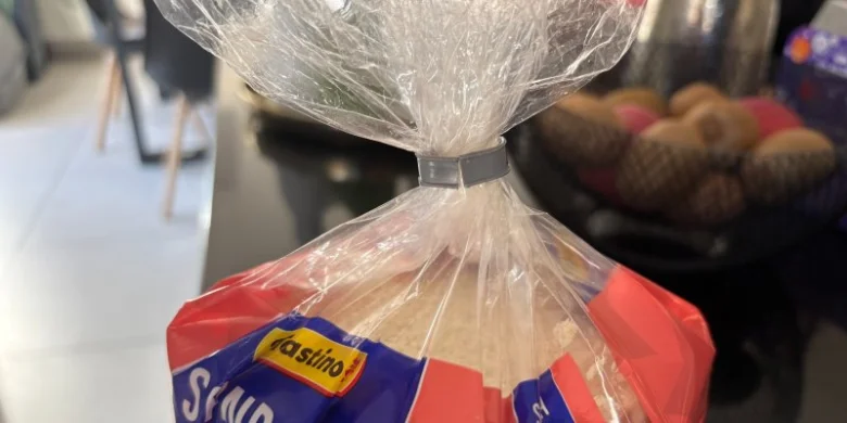 Balíček s chlebem na pultu v kuchyni.