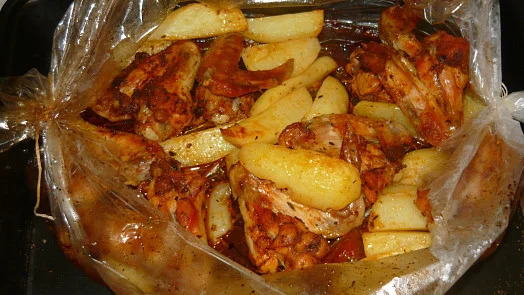 Pečené kuřecí stehna a brambory v sáčku na pečení.