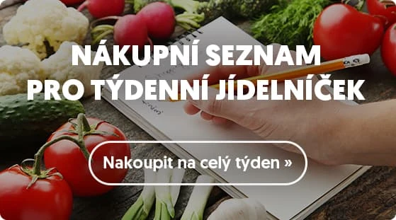 Ruka píše nákupní seznam vedle čerstvých zeleniny pro týdenní jídelníček.