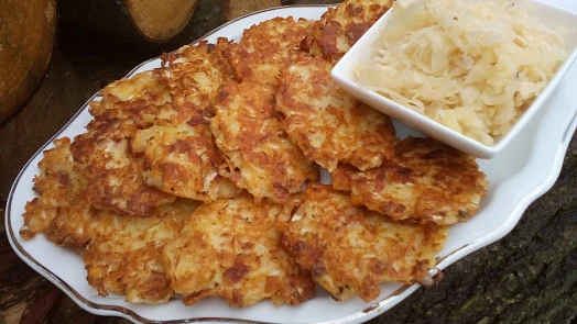 Zlaté chodské zelné placky s bledou kapustou na talíři.