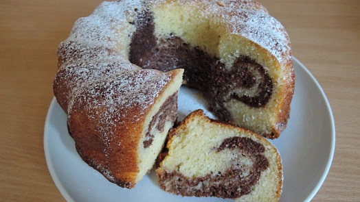 Mramorová bábovka na plechu s kouskem ukazuje vnitřní strukturu.