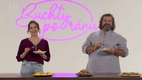 Dva hosté s palačinkami před neónovým nápisem.