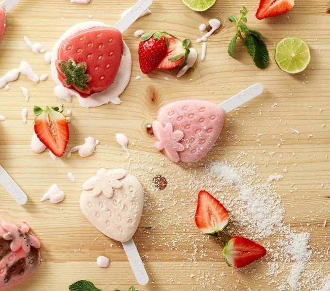 Strawberry popsicles on wood