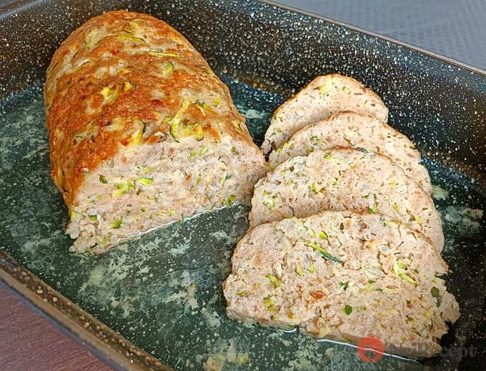 Upečená sekaná s cuketou nakrájená na plátky v pekáči.