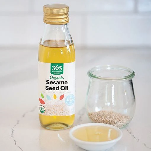 Sesame seed oil bottle and seeds