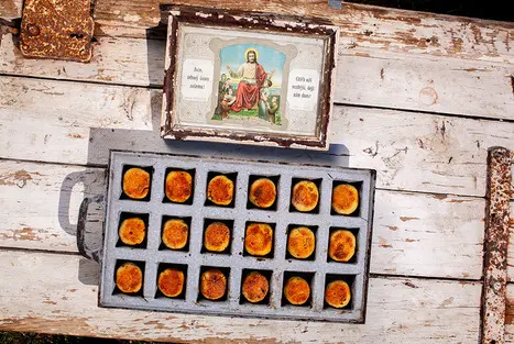 Tray of baked buřty with religious icon on wood.