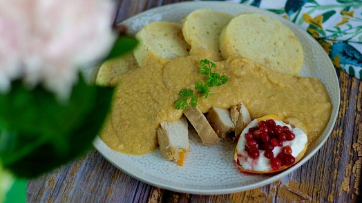 Svíčková s knedlíky a jahodovou omáčkou na talíři.
