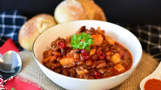 Miska fazolového guláše s masem, bramborami a petrželkou.