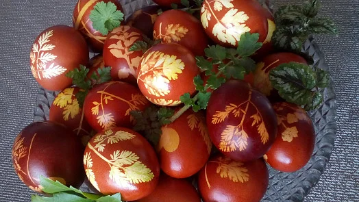 Vajíčka barvená cibulí s žlutými vzory v košíku.